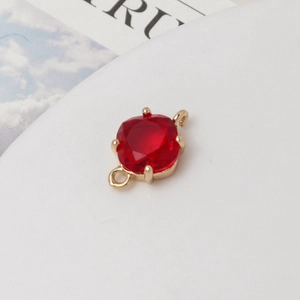 Détail d'un connecteur en pierre rouge facettée avec boucles dorées pour bijoux DIY