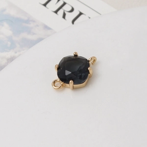Vue macro d'un pendentif en pierre noire taille coussin avec boucles dorées