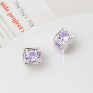 Macro shot of silver square hollow beads with purple zircon stones for DIY jewelry