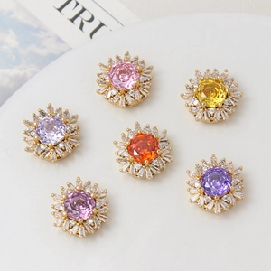 Detailed view of six colorful flower-shaped gold-plated charms with rose-cut zircon stones