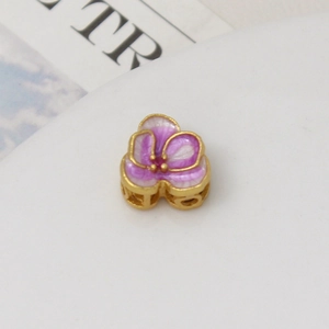 Detail of purple tulip enamel bead with gold finish and red zircon for DIY bracelets