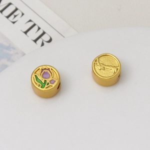 Macro shot of gold tulip and embossed flower charms for DIY jewelry making