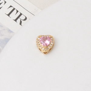 Macro shot of heart-shaped charm with pink zircon and white stones for DIY bracelets