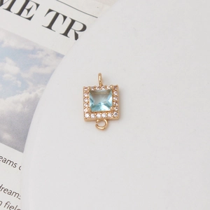 Detail eines quadratischen Goldanhängers mit hellblauem Kristall und Zirkon-Mikropavé für DIY