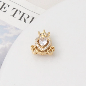 Macro shot of gold crown charm with heart-shaped zircon for DIY jewelry making
