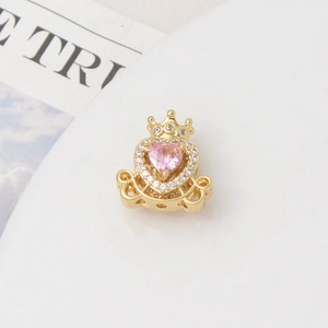 Detailed view of a gold-plated crown pumpkin carriage charm with pink heart zircon