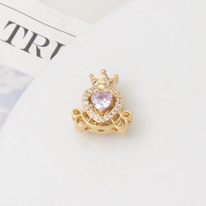 Macro view of gold plated heart charm with purple zircon and crown detail for jewelry diy