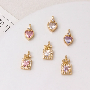 Detailed macro of heart and bottle jewelry charms with colorful micro-set zircons