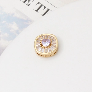 Close-up of heart-shaped purple zircon bead in gold plating for jewelry making