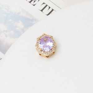 Detailed macro view of a hexagonal gold bead with purple gemstone and zircon inlay