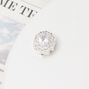 Dettaglio macro di perla argentata con micro-pave di zirconi e centro in gemma ovale