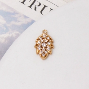 Dettaglio del ciondolo a foglia placcato oro con micro-pavé di cristalli di zircone bianco
