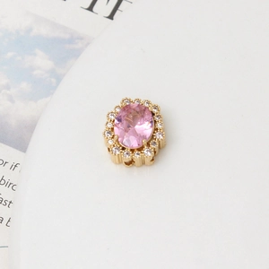 Macro shot of oval pink gemstone pendant with gold base and zircon stones