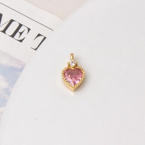 Macro shot of gold-plated heart pendant with pink zircon for DIY necklace jewelry