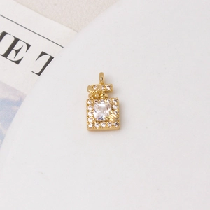 Macro detail of gold perfume bottle pendant with zircon pavé and butterfly motifs