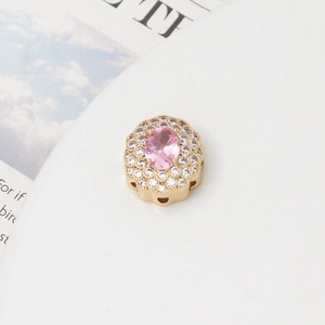 Macro view of gold-plated spacer bead with pink oval zircon and double halo crystals
