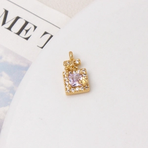 Macro view of perfume bottle charm with purple zircon and pavé butterfly details