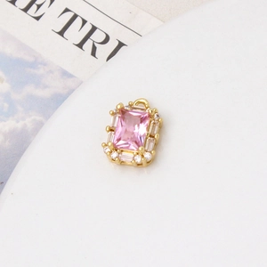 Macro detail of rectangle pink gemstone pendant with gold base and zircon stones