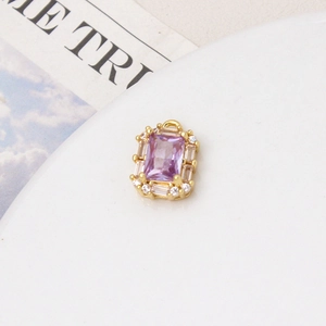 Macro detail of a gold plated rectangular pendant with purple stone and zircon border