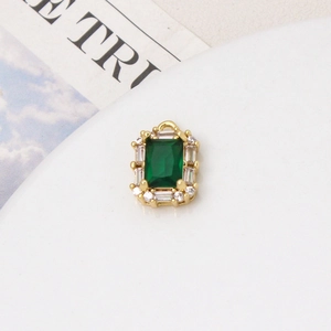 Detailed macro view of an emerald green gemstone pendant with micro-paved cubic zirconia