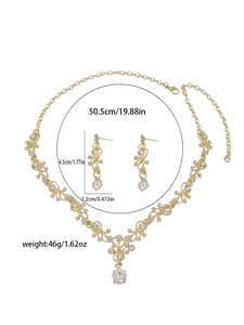 Detailed view of bridal rhinestone necklace and earrings set with floral vine patterns