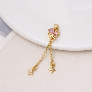 Dettaglio pendente a farfalla in oro 18K con zircone rosa e nappine a stella lucide