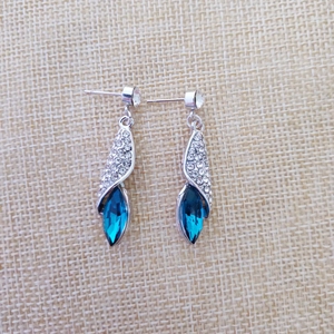 Détail de boucles d'oreilles pendantes en argent avec cristaux bleus marquise