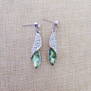 Vue détaillée de boucles d'oreilles pendantes avec pierre marquise verte et strass