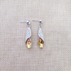 Vue détaillée des boucles d'oreilles argentées avec cristaux marquise ambre étincelants