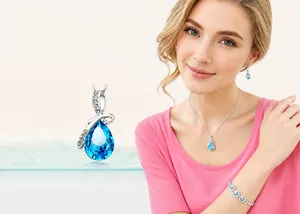 Détail de parure bijoux cristal bleu en goutte d'eau avec collier et boucles sur modèle