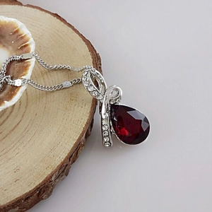 Collier élégant en argent avec une pierre rouge en forme de goutte et cristaux