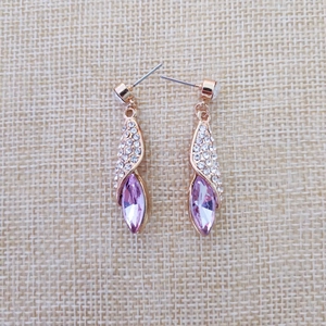 Gros plan de boucles d'oreilles or rose avec cristal rose marquise et pavé de strass