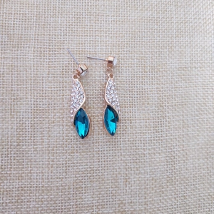 Vue détaillée de boucles d'oreilles rose doré avec cristal bleu marquise et pavé de strass