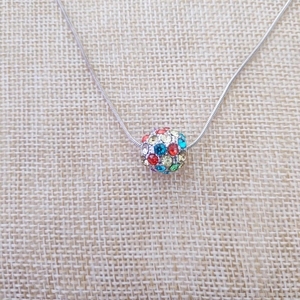 Dettaglio di una collana a catena serpente d'argento con ciondolo a sfera in cristalli