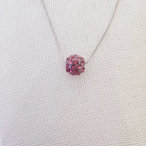 Dettaglio ravvicinato della catena a serpente argento con ciondolo a sfera rosa