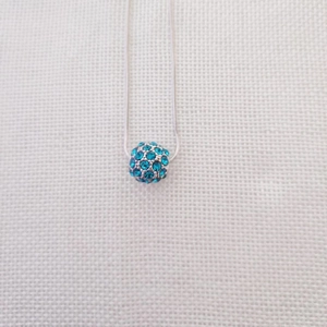 Dettaglio ravvicinato di una collana a catena a serpente d'argento con ciondolo a sfera blu