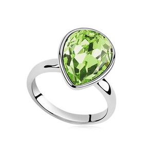 Fashion silver ring featuring a large pear-cut green crystal centerpiece in white background