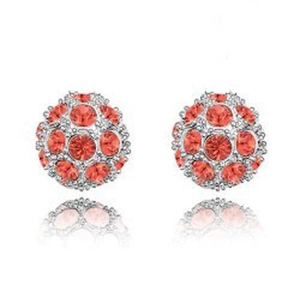 Dettaglio di orecchini a lobo sferici con cristalli rossi brillanti e base argento