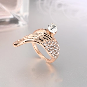 Elegante anillo de alas de ángel en oro rosa con cristales sobre fondo lujoso