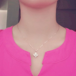 Elegant gold four-leaf clover necklace with AAA zirconia pendant on model's neck