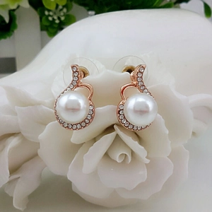 Boucles d'oreilles dorées roses avec perles blanches et halo de strass étincelants