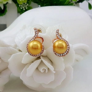 Élégantes boucles d'oreilles perles dorées avec strass brillants sur pétales de rose