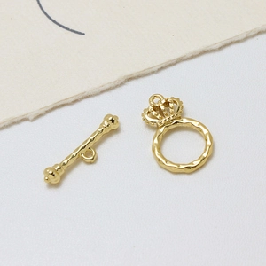 Détail du fermoir à bascule couronne plaqué or 14K avec texture martelée pour bijoux