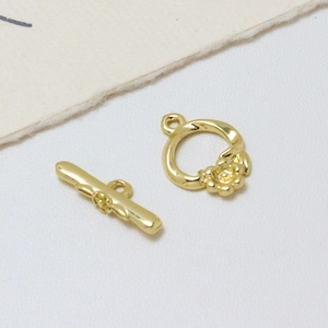 Gros plan sur le fermoir à bascule fleur doré pour la création de bijoux DIY