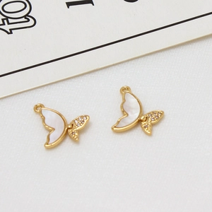 Détail macro de pendentifs papillons dorés avec nacre blanche et incrustation de zircon