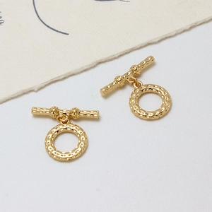 Vue macro d'un fermoir OT couronne tulipe plaqué or avec texture martelée pour bijoux DIY