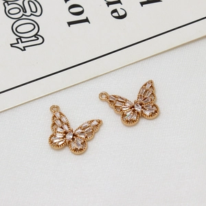 Vue détaillée macro de pendentifs papillon dorés ajourés sertis de zircons rectangulaires