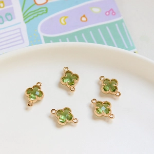 Detailed close-up of 5 green faceted crystal clover connectors with gold frames for DIY