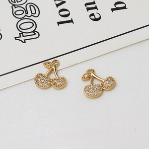 Close-up of golden cherry charms with micro-pave white zircon for DIY jewelry making