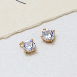 Detail of round cubic zirconia pendants with gold-plated four-prong setting for DIY jewelry